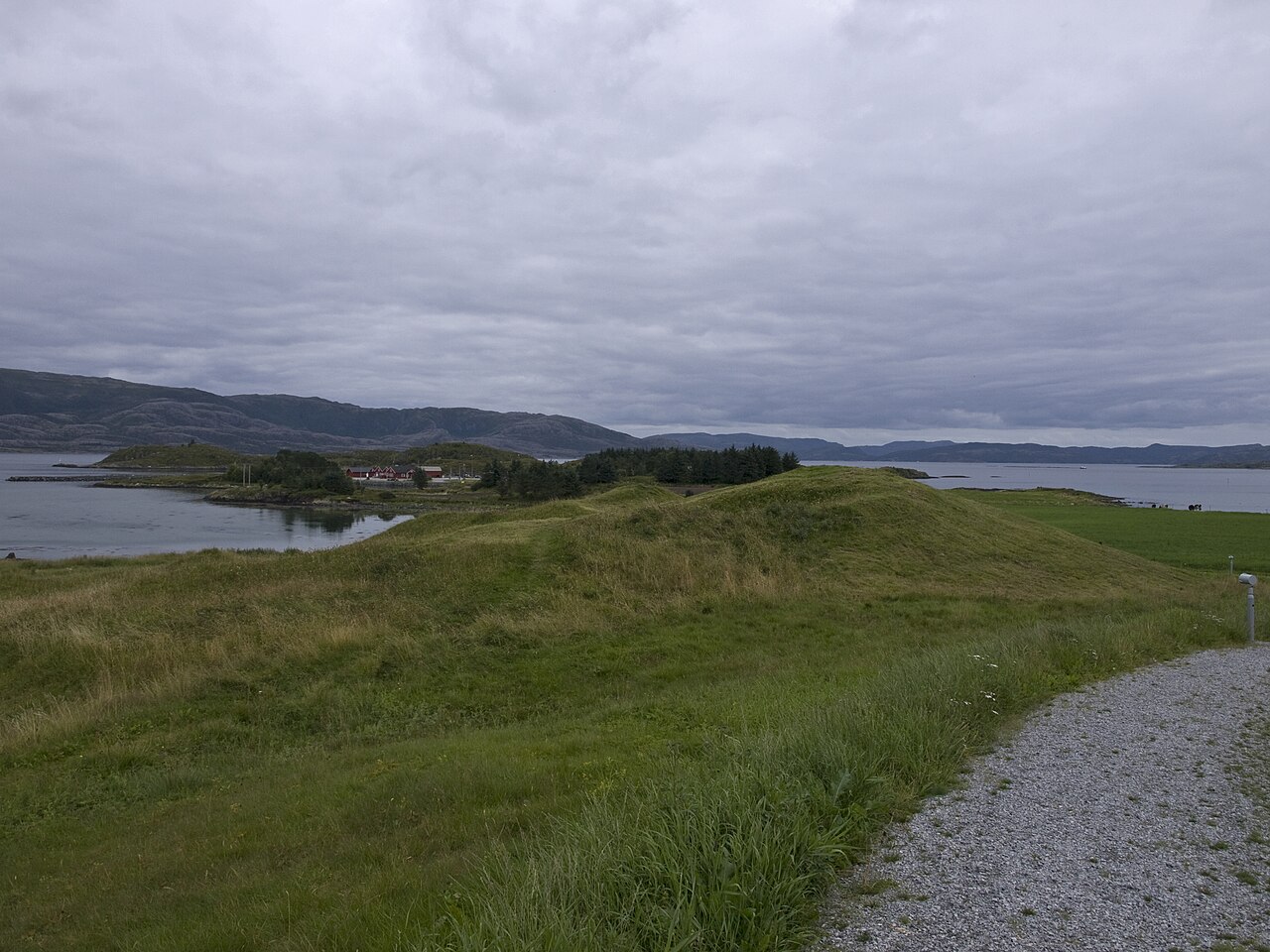 Grass-covered Viking burial mounds on the shore of Leka island, Norway, site of the Herlaugshaugen ship burial